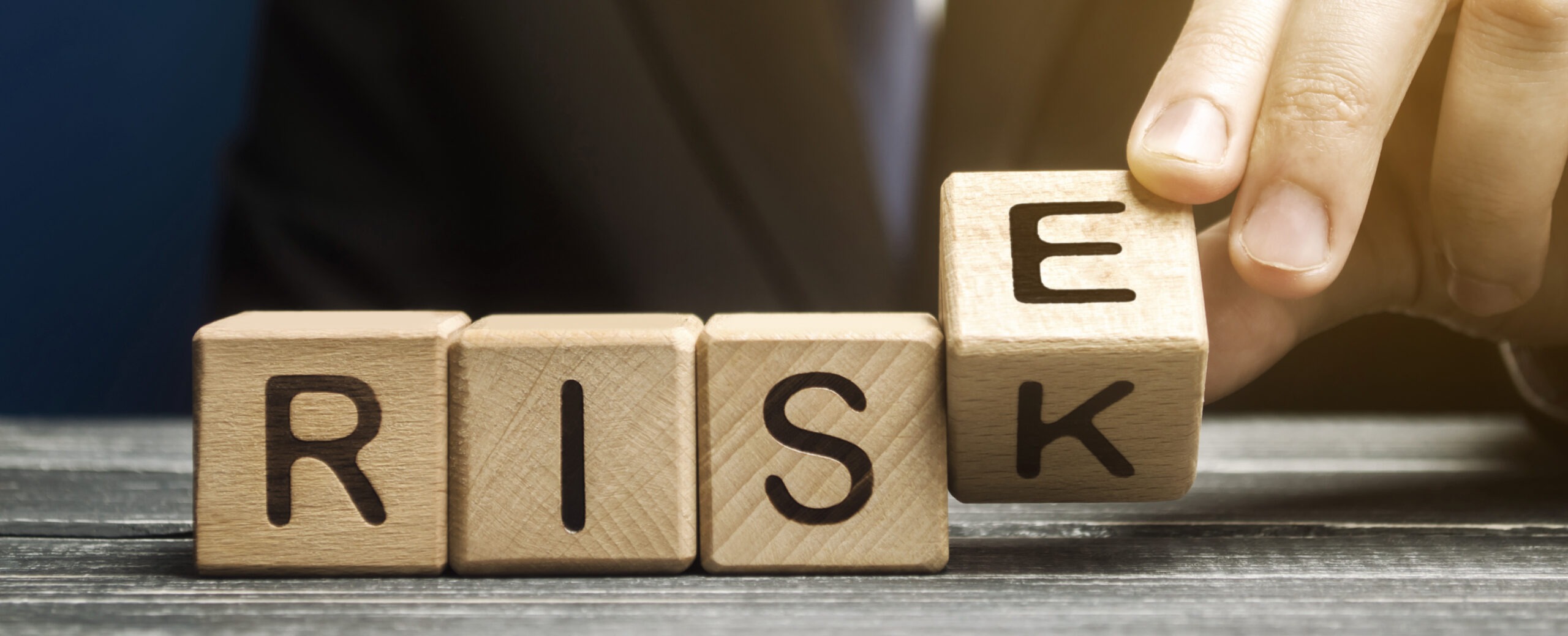 Businessman changes wooden blocks with the words Risk and Rise. Business risk management and growth performance. Risks assessment. Planning strategies and achieving goals.